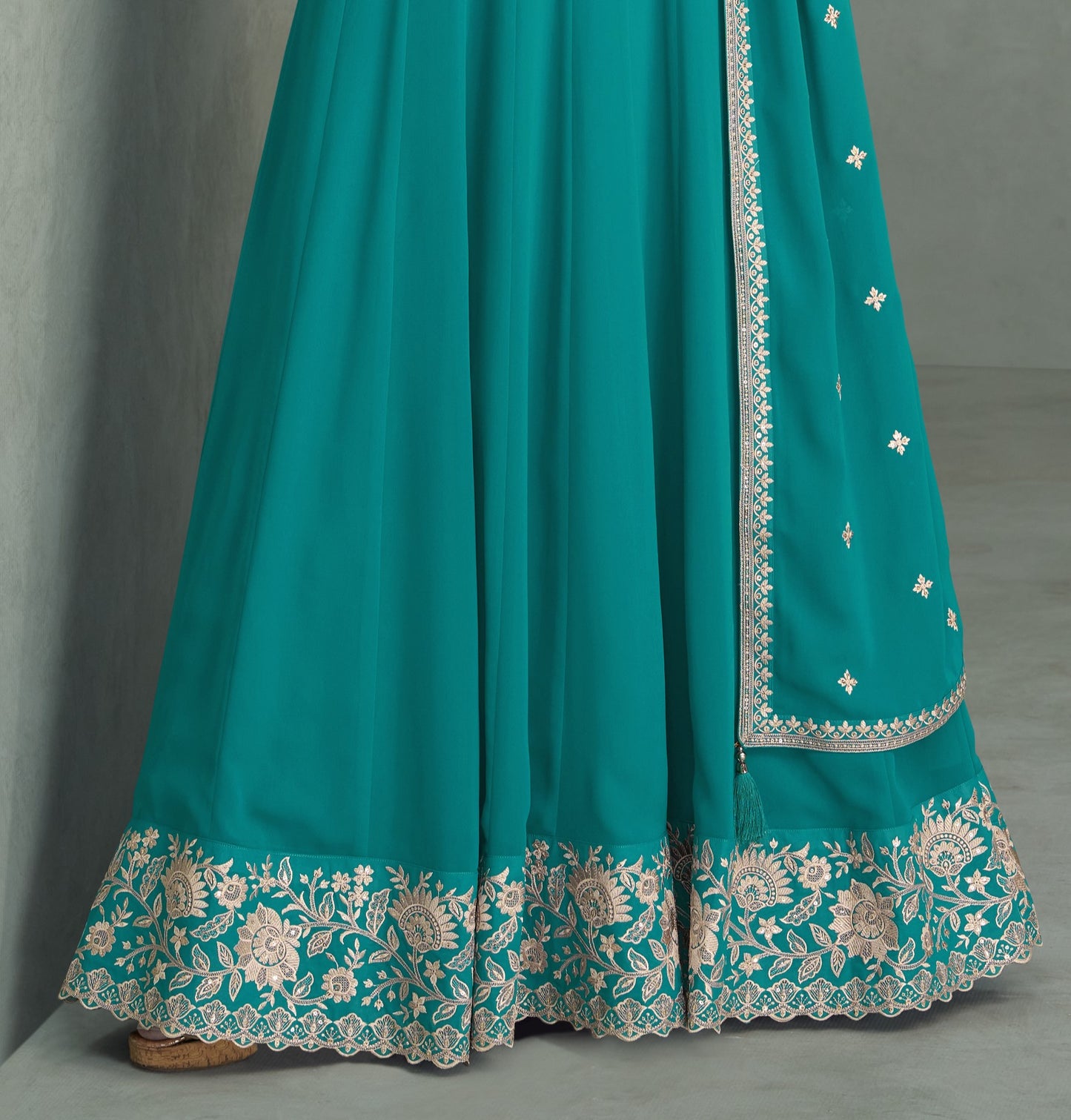 Teal blue color Anarkali gown in georgette fabric with sequin and embroidery work, blending vibrant sophistication with festive appeal.