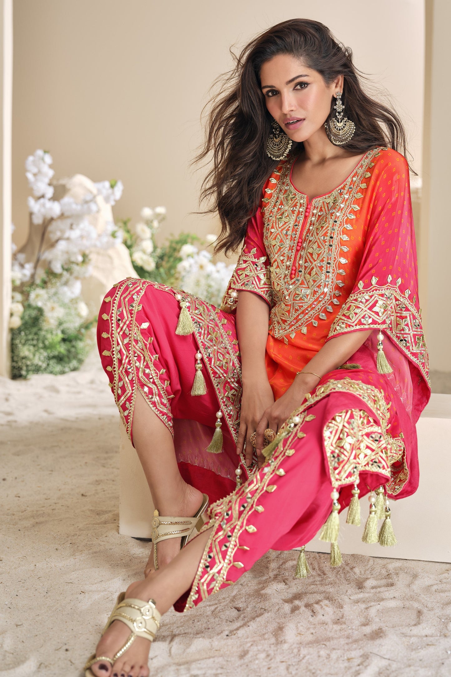 Orange color palazzo suit in viscose silk with radiant mirror work and embellished details, perfect for vibrant and joyful celebrations.