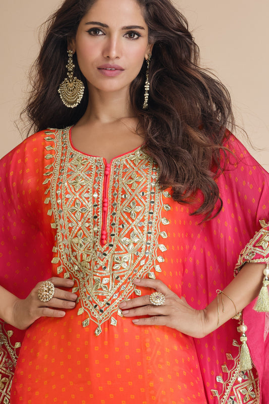 Orange color palazzo suit in viscose silk with radiant mirror work and embellished details, perfect for vibrant and joyful celebrations.