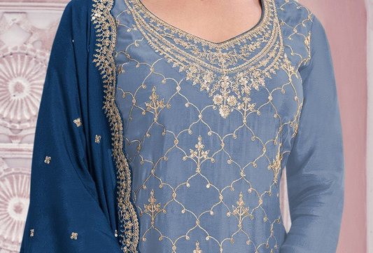 A close-up of a blue traditional outfit with intricate gold embroidery on the neckline and across the front, paired with a matching blue dupatta featuring gold border detailing.