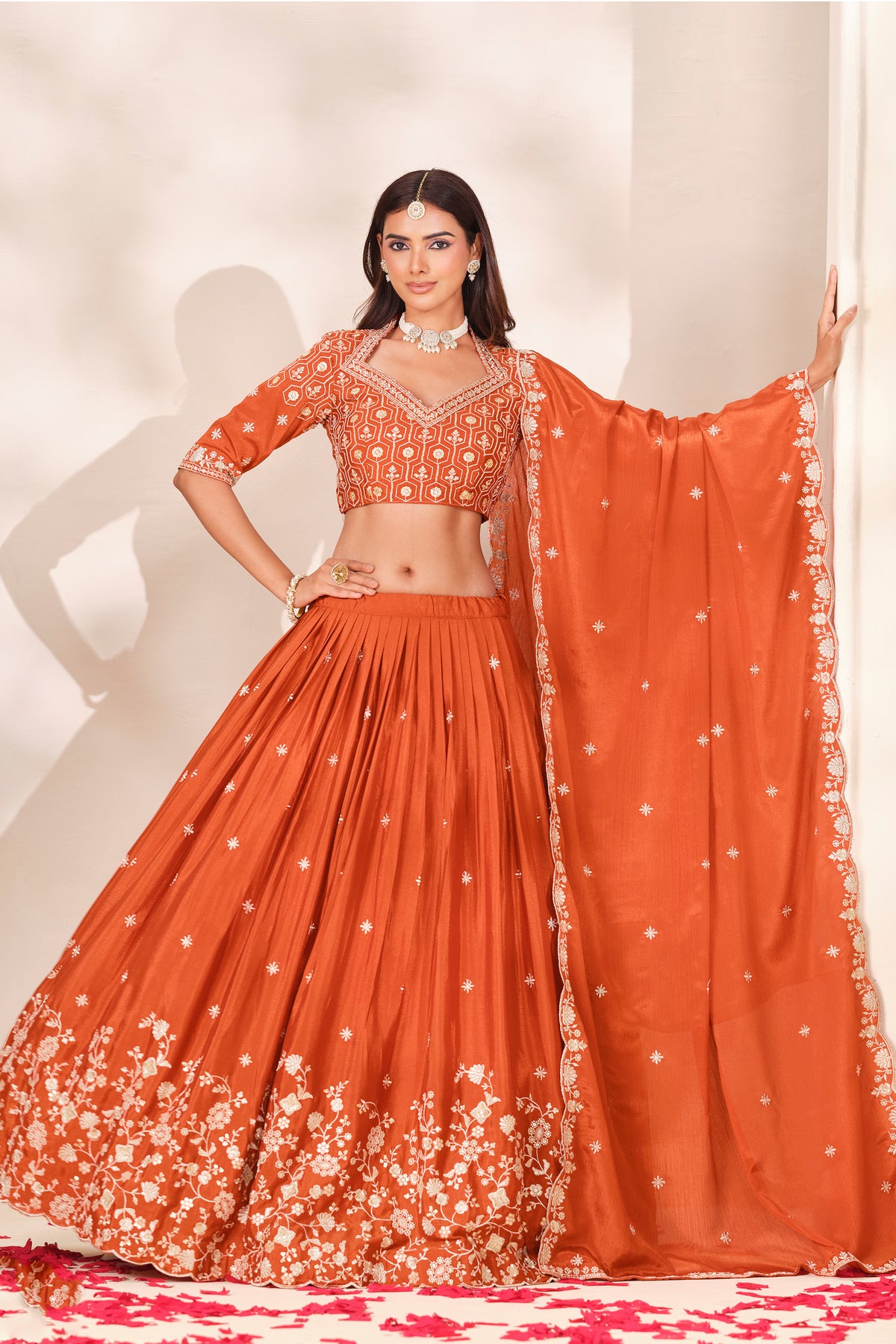 Orange lehenga choli with dupatta arranged for a festive look.
