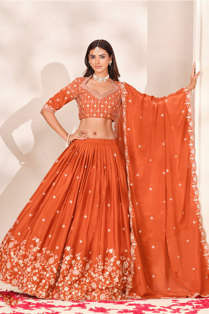 Orange lehenga choli with dupatta arranged for a festive look.