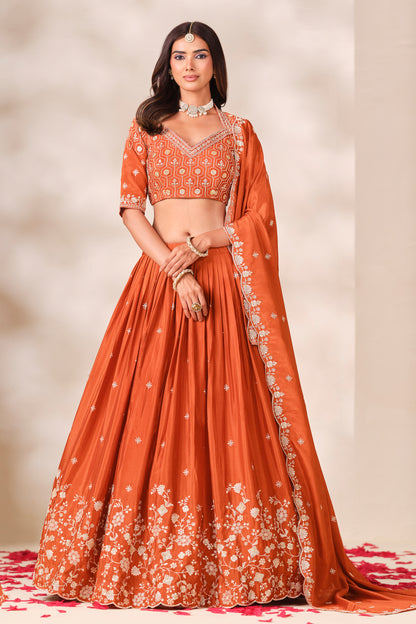 Orange lehengha choli suit with heavy embroidery work, front view.