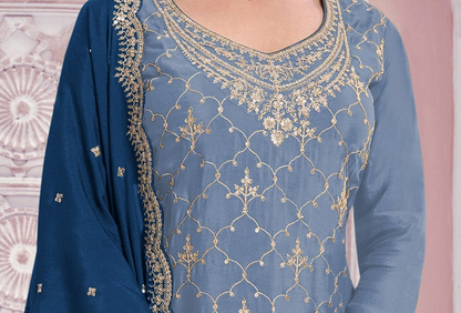 A close-up of a blue traditional outfit with intricate gold embroidery on the neckline and across the front, paired with a matching blue dupatta featuring gold border detailing.
