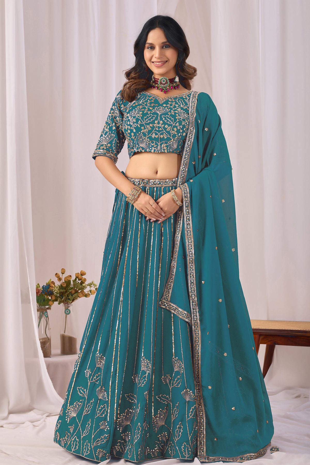 Teal blue women's wedding wear with embroidered lehenga choli, front view.
